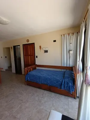 a bedroom with a bed with a blue comforter at Complejo Refugio Playa Perelli in Villa Carlos Paz
