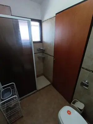 a bathroom with a shower stall and a toilet at Complejo Refugio Playa Perelli in Villa Carlos Paz