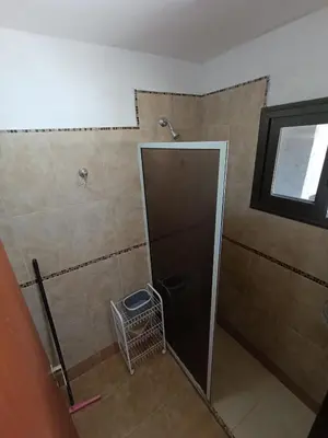 a bathroom with a shower with a glass door at Complejo Refugio Playa Perelli in Villa Carlos Paz