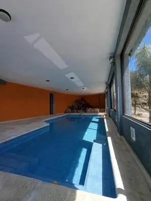 a swimming pool in a building with a large window at Complejo Refugio Playa Perelli in Villa Carlos Paz