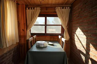 a dining room with a table and a window at Cabañas del Peñón in La Cumbrecita