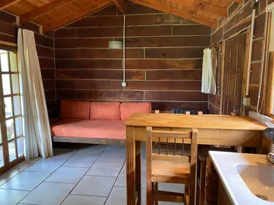 a room with a bench in the corner of a room at Cabañas del Peñón in La Cumbrecita
