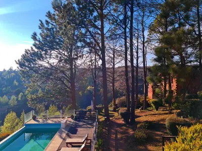 a house with a swimming pool and trees at Cabañas del Peñón in La Cumbrecita