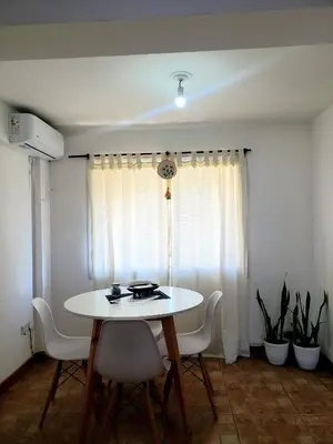 a dining room with a white table and chairs at Departamento en Barrio Centro calle Corro in Cordoba