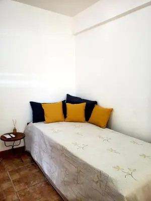 a bed in a room with yellow pillows on it at Departamento en Barrio Centro calle Corro in Cordoba