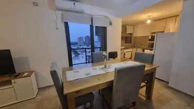 a kitchen with a wooden table with chairs and a large window at Premium Apartamento in Río Cuarto