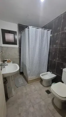 a bathroom with a toilet and a shower and a sink at Premium Apartamento in Río Cuarto