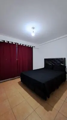 a bedroom with a black bed and red curtains at Cordoba sobre Costanera 2 dormitorios con Estacionamiento in Cordoba