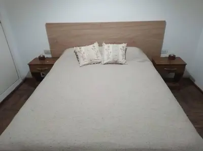 a large bed with two tables and two pillows on it at En el corazón de Barrio General Paz, Cordoba in Cordoba