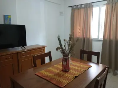 a dining room table with a vase of flowers on it at En el corazón de Barrio General Paz, Cordoba in Cordoba