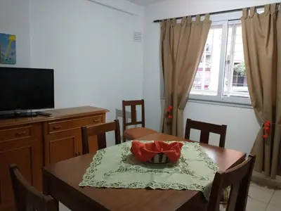 a dining room with a table and a television at En el corazón de Barrio General Paz, Cordoba in Cordoba