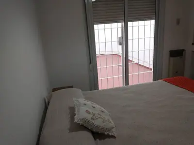 a bed with a pillow on it in a room with a window at En el corazón de Barrio General Paz, Cordoba in Cordoba