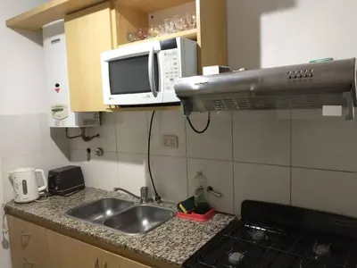a kitchen with a sink and a microwave at En el corazón de Barrio General Paz, Cordoba in Cordoba