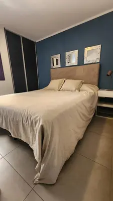 a large bed in a bedroom with a blue wall at Departamento -Brasil- Pleno Nueva Cordoba By Apartcba in Cordoba