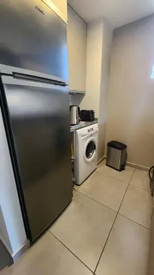 a kitchen with a refrigerator and a washing machine at Departamento -Brasil- Pleno Nueva Cordoba By Apartcba in Cordoba