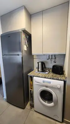 a kitchen with a refrigerator and a washing machine at Departamento -Brasil- Pleno Nueva Cordoba By Apartcba in Cordoba