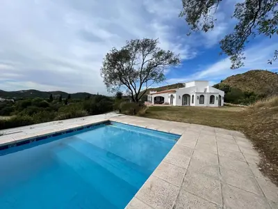 a swimming pool in front of a house at Casa en Potrerillo de Larreta Magicas Vistas in Alta Gracia