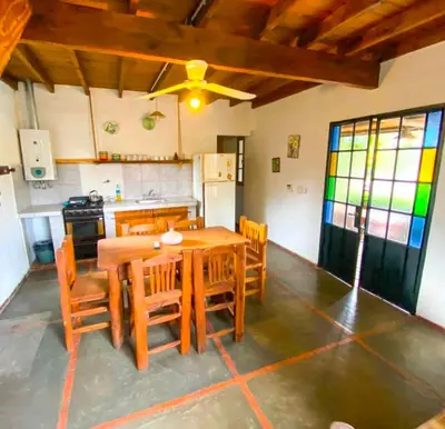 a dining room with a wooden table and chairs at cabañas el viejo ciprés 2 in Santa Rosa de Calamuchita