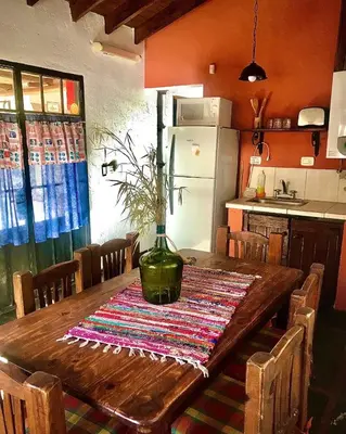 a kitchen with a wooden table with a vase on it at cabañas el viejo ciprés 2 in Santa Rosa de Calamuchita