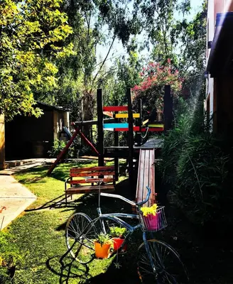 a bike parked in the grass next to a bench at cabañas el viejo ciprés 2 in Santa Rosa de Calamuchita