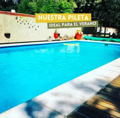 a swimming pool in a resort with a sign that reads nucriseria plaza at cabañas el viejo ciprés 2 in Santa Rosa de Calamuchita