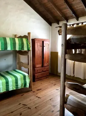 a room with two bunk beds and a wooden floor at cabañas el viejo ciprés 3 in Santa Rosa de Calamuchita