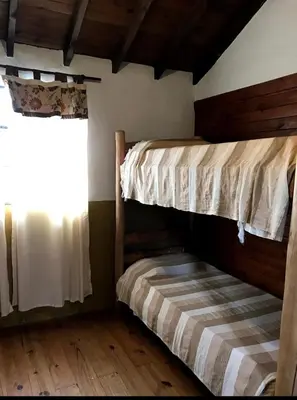 two bunk beds in a room with a window at cabañas el viejo ciprés 3 in Santa Rosa de Calamuchita