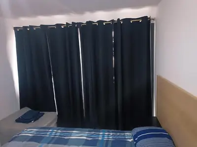 a bed with black curtains in a bedroom at Dpto amoblado in Cordoba
