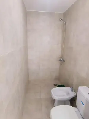 a white bathroom with a toilet and a shower at Dpto amoblado in Cordoba