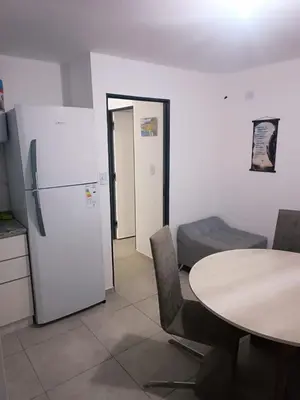 a kitchen with a table and a refrigerator and a table and chairs at Dpto amoblado in Cordoba