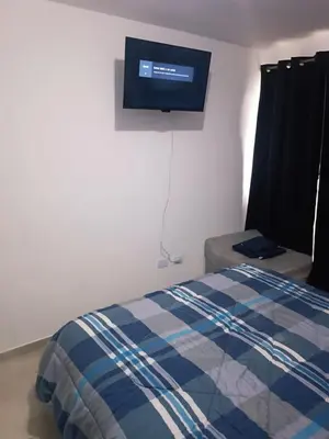 a bedroom with a bed and a tv on the wall at Dpto amoblado in Cordoba