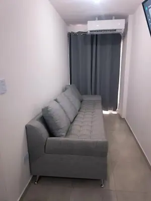 a gray couch in a room with a window at Dpto amoblado in Cordoba