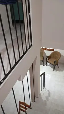 a room with a staircase with chairs and a table at Dpto amueblado con cochera descubierta in Río Tercero