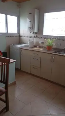 a kitchen with white cabinets and a sink and a window at Dpto amueblado con cochera descubierta in Río Tercero