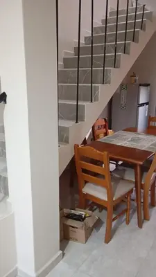 a dining room with a table and a chair and stairs at Dpto amueblado con cochera descubierta in Río Tercero