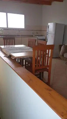 a kitchen with a wooden table and a table and chairs at Dpto amueblado con cochera descubierta in Río Tercero