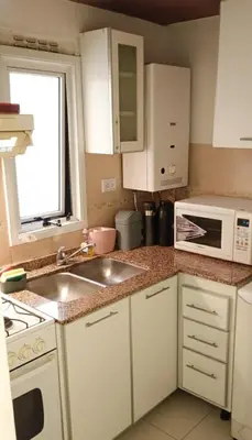 a kitchen with a sink and a microwave at Rincón del Poeta - Ubicación destacada - Nueva Córdoba in Cordoba