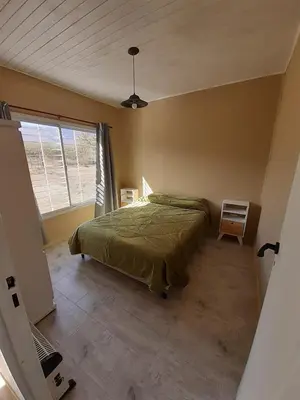 a bedroom with a green bed and a window at El Alto in Yacanto