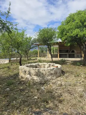 a stone bowl in front of a house with trees at El Alto in Yacanto