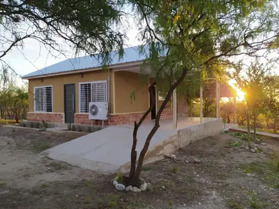 a house with a tree in front of it at El Alto in Yacanto