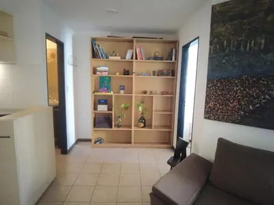 a living room with a couch and a book shelf at Apartamento al 5' del Centro in Cordoba