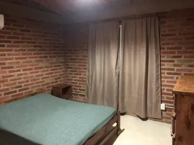 a bedroom with a bed and a window with a curtain at Cabaña RUSTICA exclusiva para 6 personas toda equipada in Carpintería