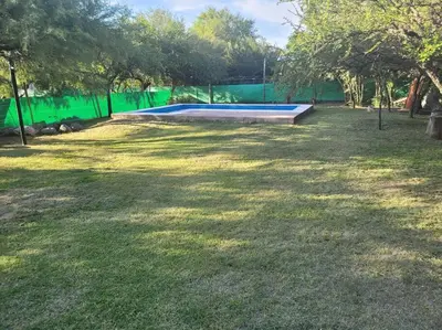 a pool in a yard with a green fence at Cabaña RUSTICA exclusiva para 6 personas toda equipada in Carpintería