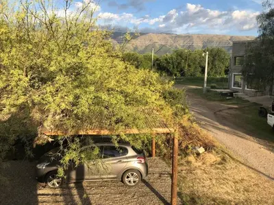 a car parked under a tree in a driveway at Cabaña RUSTICA exclusiva para 6 personas toda equipada in Carpintería