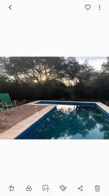 a picture of a swimming pool with a chair at Cabaña RUSTICA exclusiva para 6 personas toda equipada in Carpintería
