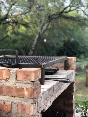 a brick wall with a grill on top of it at Cabaña RUSTICA exclusiva para 6 personas toda equipada in Carpintería
