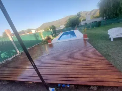 a wooden deck with a pool in a yard at La soñada in San Antonio de Arredondo