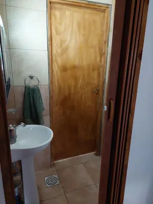 a bathroom with a sink and a wooden door at La soñada in San Antonio de Arredondo
