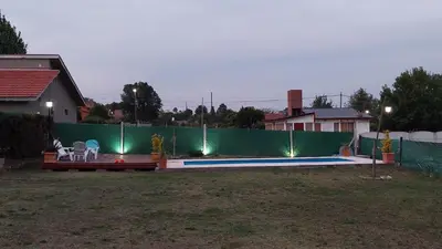 a backyard with a fence and a swimming pool with lights at La soñada in San Antonio de Arredondo