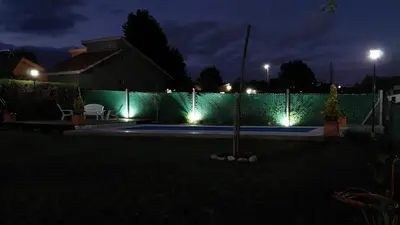 a fence with lights in a yard at night at La soñada in San Antonio de Arredondo
